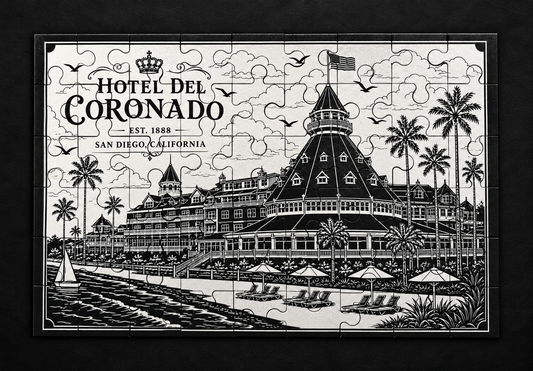 Black and white Hotel del Coronado metal jigsaw puzzle showing the historic beachfront hotel, palm trees, and beach chairs.