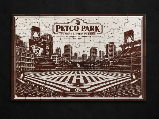 Brown Petco Park metal jigsaw puzzle with etched artwork of the San Diego baseball stadium and city skyline, lying flat on a dark surface.