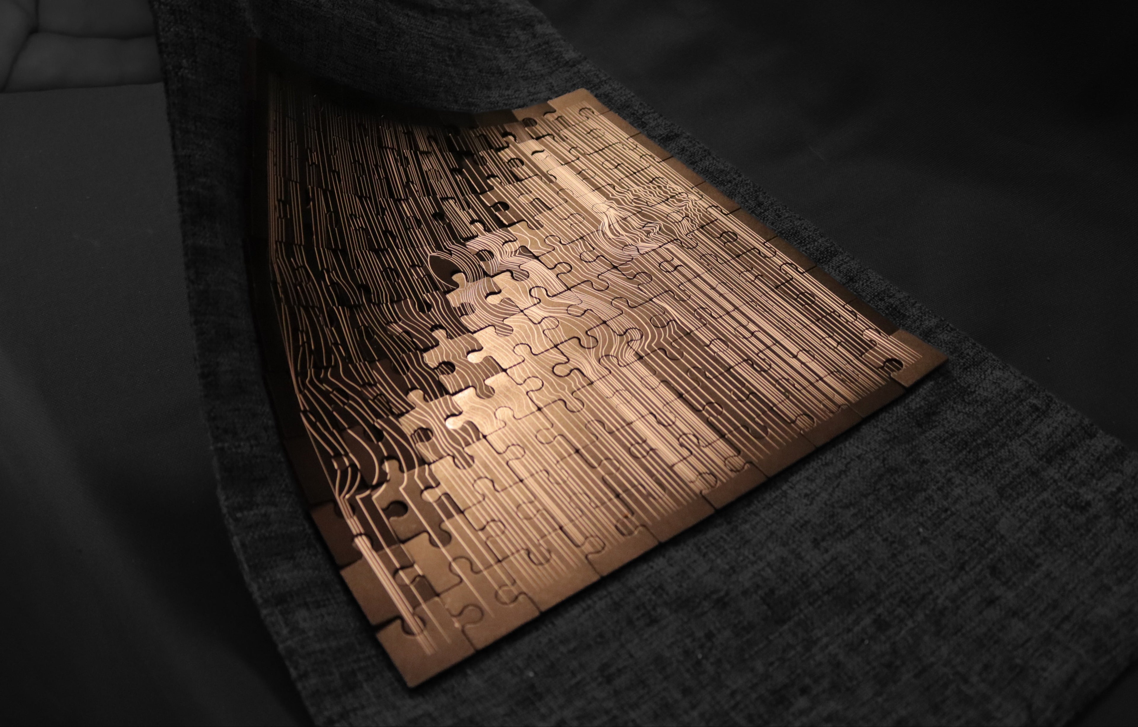 Metal jigsaw puzzle reflecting light and shadowns 